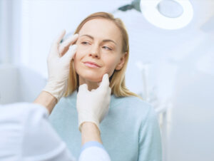 A woman having her face be examined by a doctor