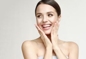 A woman smiling and holding her hands against her face