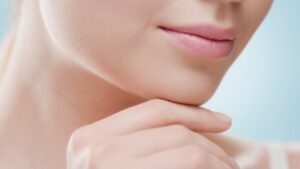 A close-up of a woman resting her chin on her hand