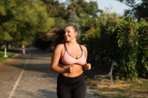 A woman smiling while jogging outside